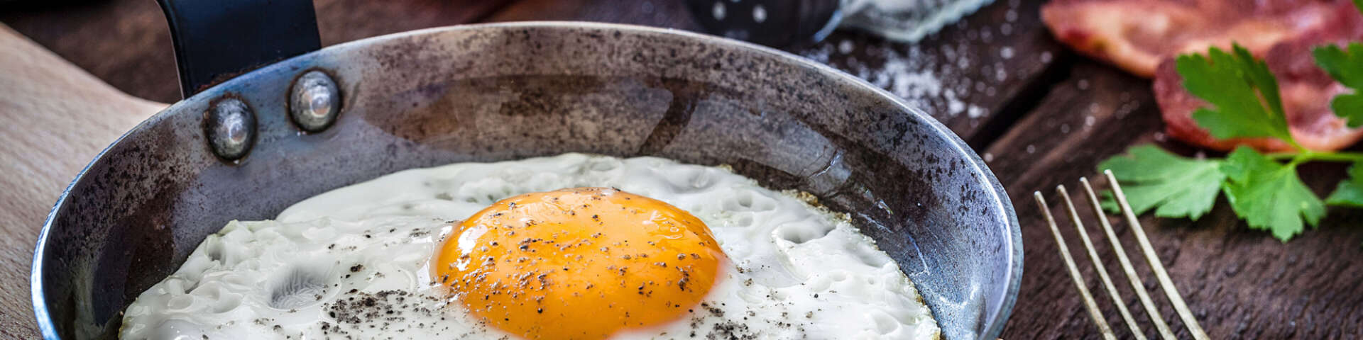 A small cast-iron pan, with a single fried egg.